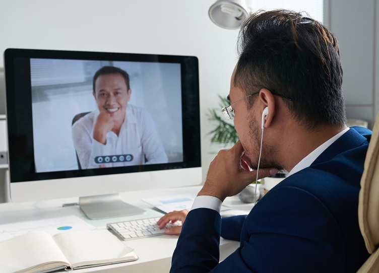Entrepreneur sitting at his table and videocalling to business partner